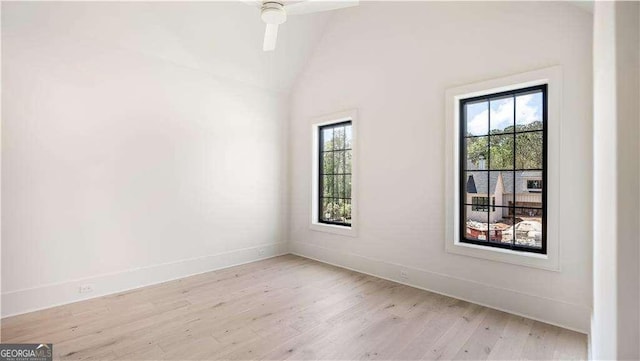 unfurnished room with light wood-style floors, baseboards, vaulted ceiling, and ceiling fan