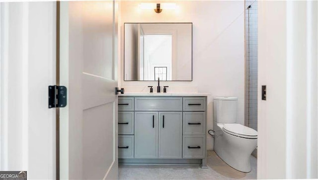 bathroom featuring toilet, vanity, and baseboards