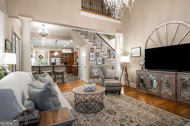 240 Trotters Rdg, Fayetteville, GA 30215 - living room with decorative columns, light wood finished floors, and a chandelier