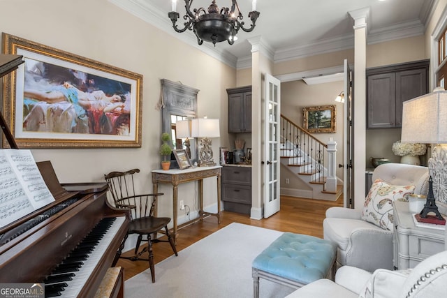 240 Trotters Rdg, Fayetteville, GA 30215 - living area with crown molding, light wood-style floors, decorative columns, stairs, and a notable chandelier