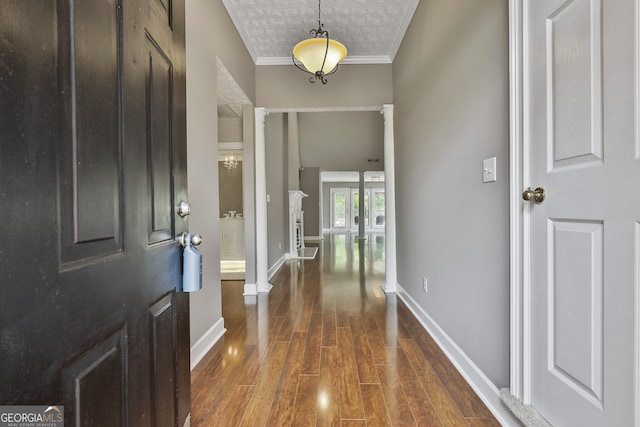 135 Fairway Ct, Newnan, GA 30265 - entryway with dark wood-style floors, crown molding, ornate columns, baseboards, and a textured ceiling