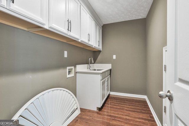 135 Fairway Ct, Newnan, GA 30265 - laundry area featuring dark wood-style floors, washer hookup, baseboards, cabinet space, and a textured ceiling