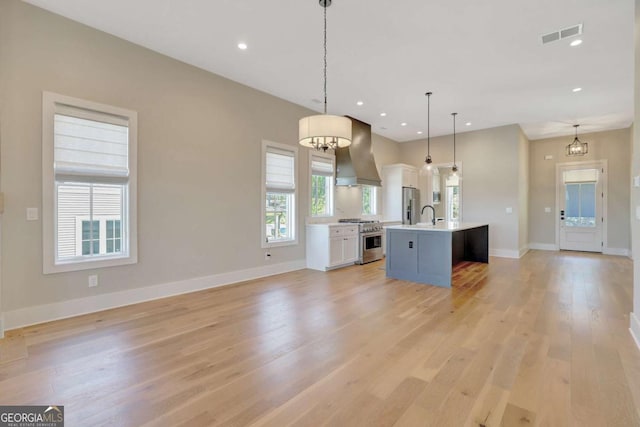 1130 Lupo Loop, Chattahoochee Hills, GA 30268 - kitchen with wall chimney range hood, appliances with stainless steel finishes, open floor plan, light countertops, and recessed lighting