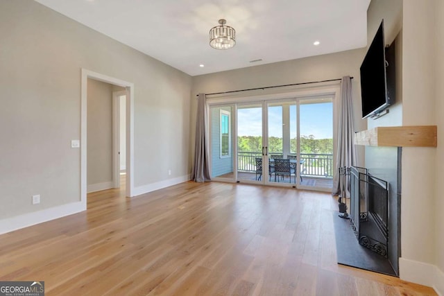 1130 Lupo Loop, Chattahoochee Hills, GA 30268 - unfurnished living room featuring a fireplace, light wood finished floors, and recessed lighting