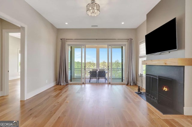 1130 Lupo Loop, Chattahoochee Hills, GA 30268 - living area featuring wood finished floors, a fireplace with flush hearth, and a chandelier