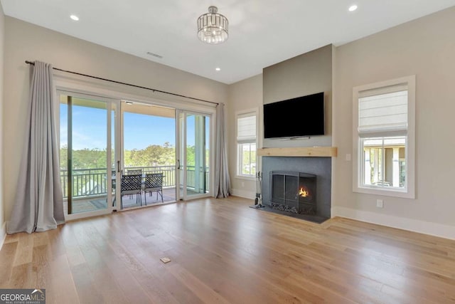 1130 Lupo Loop, Chattahoochee Hills, GA 30268 - unfurnished living room featuring healthy amount of natural light, wood finished floors, a fireplace with flush hearth, and recessed lighting