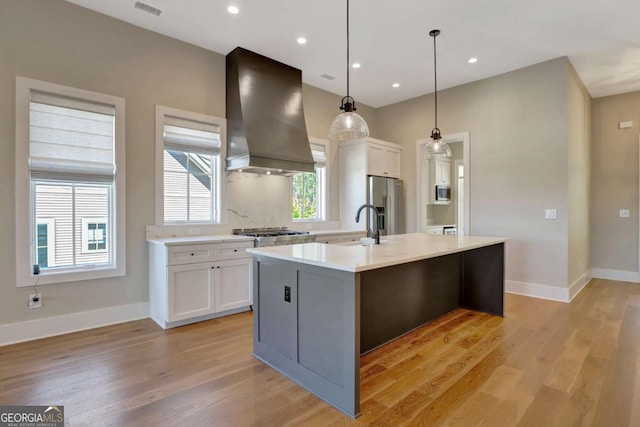 1130 Lupo Loop, Chattahoochee Hills, GA 30268 - kitchen with premium range hood, stainless steel appliances, white cabinets, an island with sink, and light wood-type flooring