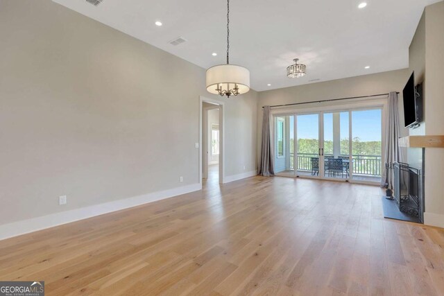 1130 Lupo Loop, Chattahoochee Hills, GA 30268 - unfurnished living room featuring light wood-style flooring, a chandelier, and recessed lighting