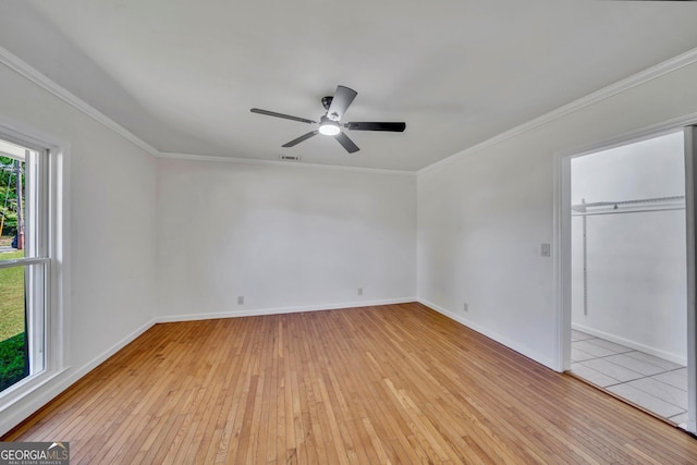 unfurnished bedroom with crown molding, visible vents, light wood-style flooring, and baseboards