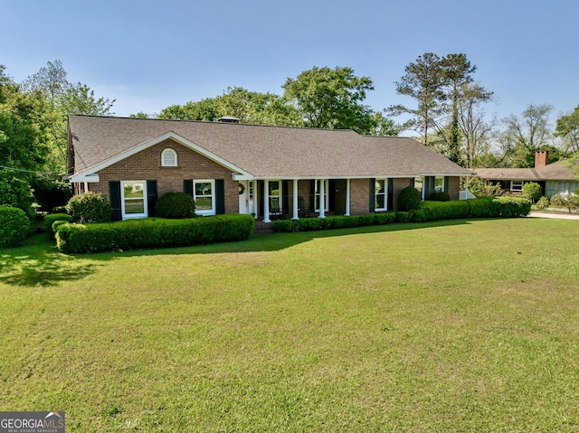 ranch-style house with a shingled roof, a front yard, and brick siding