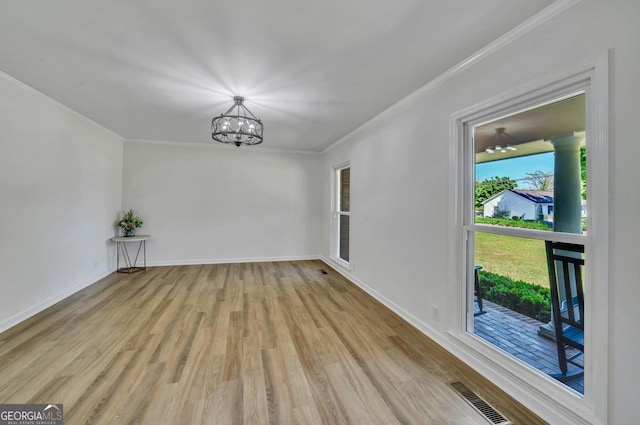 unfurnished dining area with crown molding, visible vents, an inviting chandelier, and light wood-style floors