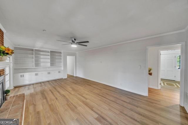 unfurnished living room featuring baseboards, a brick fireplace, ornamental molding, a ceiling fan, and light wood-style floors