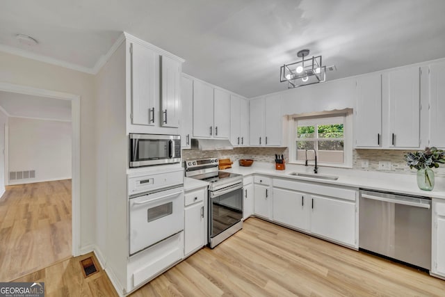 kitchen with visible vents, light countertops, a sink, stainless steel appliances, and decorative backsplash