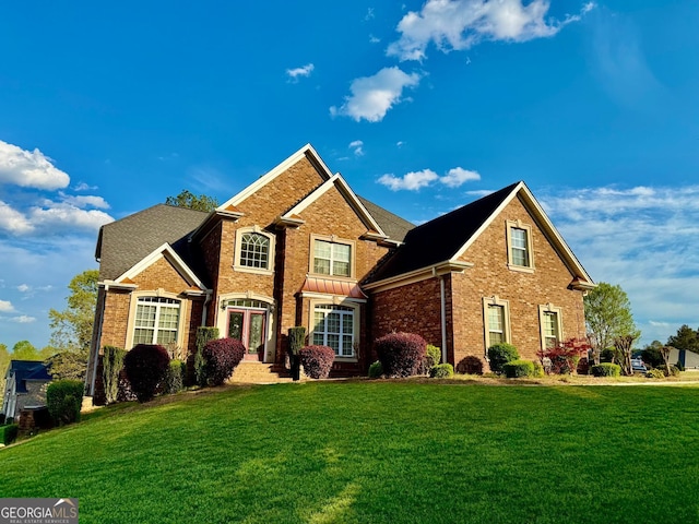 view of front of property with a front yard and brick siding
