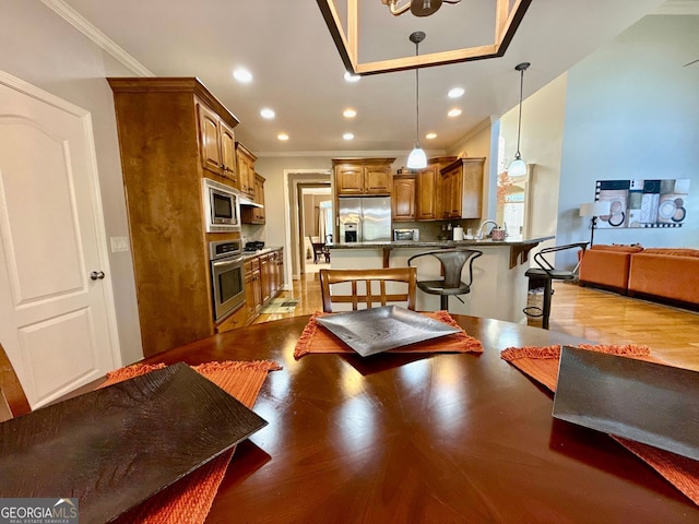 living room with wood finished floors, ornamental molding, and recessed lighting