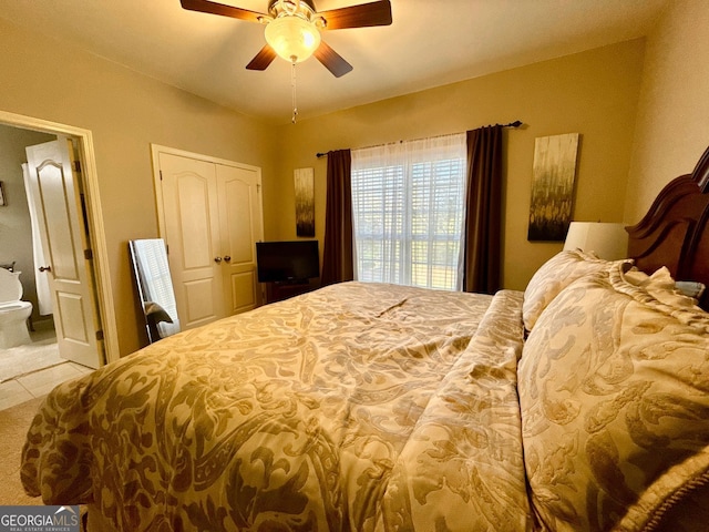 bedroom featuring tile patterned floors, ensuite bathroom, and ceiling fan