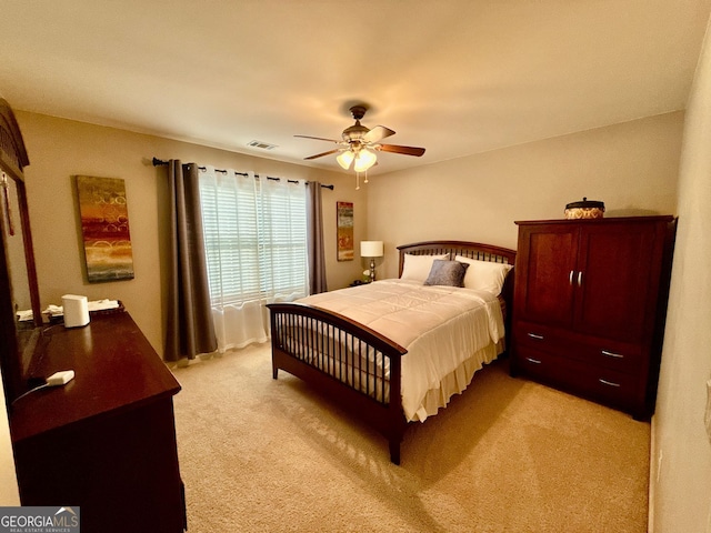 bedroom with visible vents, ceiling fan, and light colored carpet