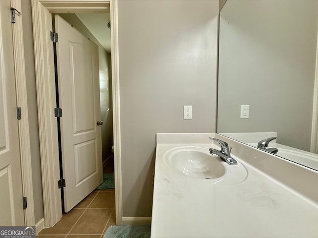 bathroom featuring toilet, tile patterned floors, vanity, and baseboards