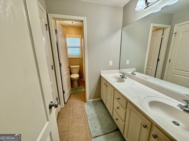 full bath featuring tile patterned floors, double vanity, a sink, and toilet