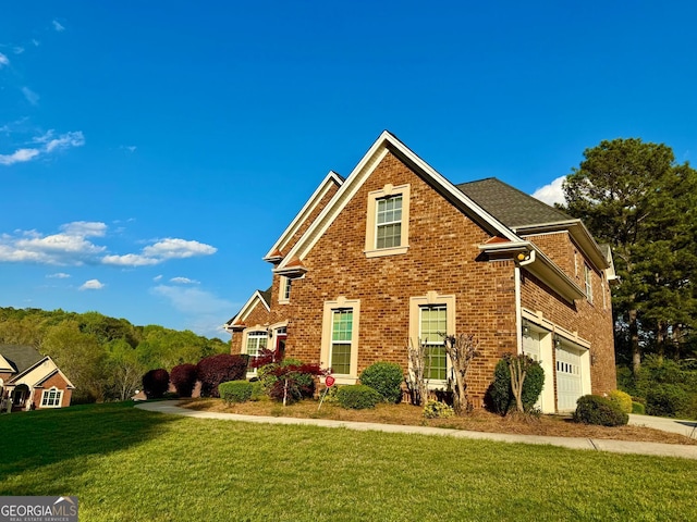 traditional-style home with brick siding, an attached garage, and a front lawn