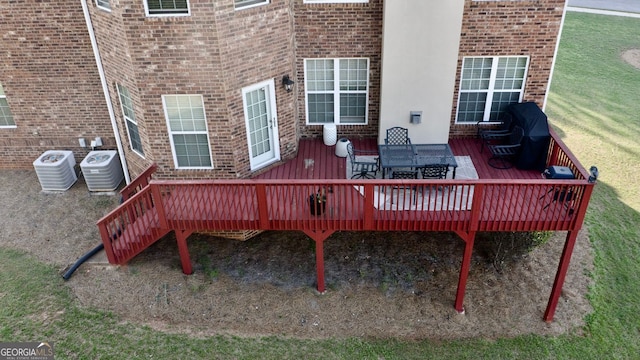 wooden terrace with a yard, a grill, cooling unit, and outdoor dining area