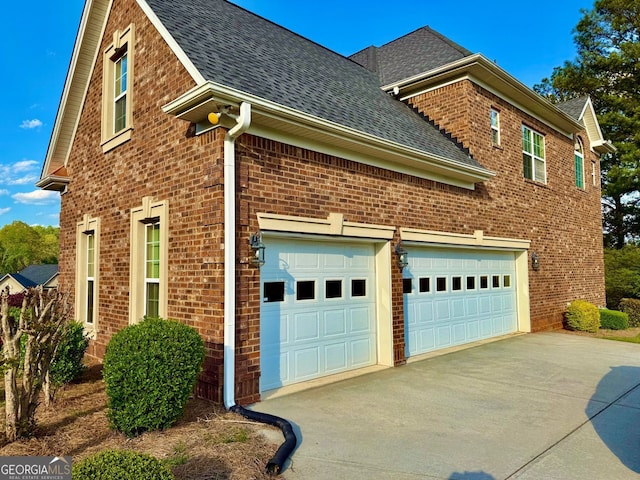 view of side of property featuring brick siding, a shingled roof, and driveway
