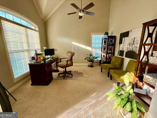 carpeted office space with high vaulted ceiling, baseboards, ornamental molding, and ceiling fan