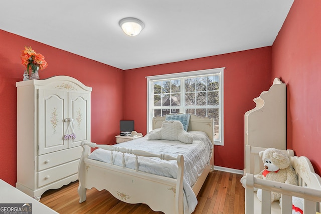 bedroom with baseboards and wood finished floors