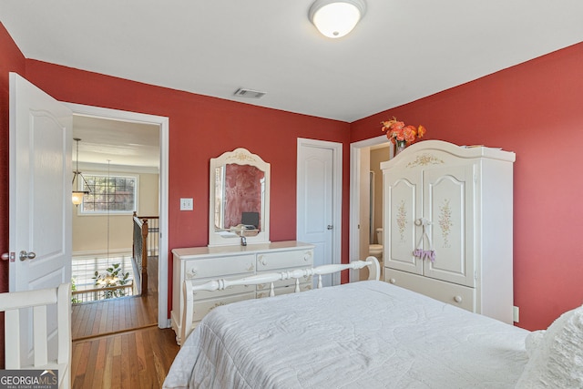 bedroom featuring visible vents and wood finished floors