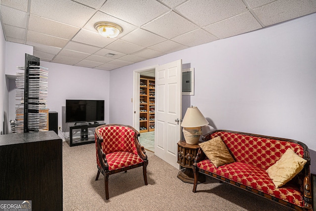 living area with carpet flooring, a paneled ceiling, and visible vents