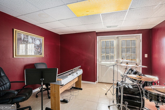 office area featuring light tile patterned floors, baseboards, a paneled ceiling, and visible vents