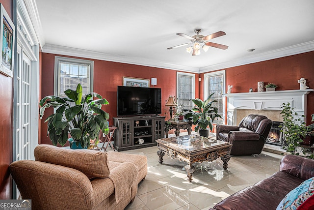 living area featuring a warm lit fireplace, a ceiling fan, marble finish floor, and crown molding