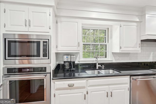 918 Guinevere Way SW, Lilburn, GA 30047 - kitchen with stainless steel appliances, white cabinetry, tasteful backsplash, dark countertops, and ornamental molding