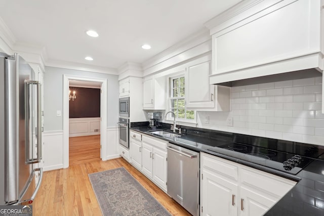 918 Guinevere Way SW, Lilburn, GA 30047 - kitchen featuring appliances with stainless steel finishes, white cabinetry, decorative backsplash, light wood finished floors, and crown molding