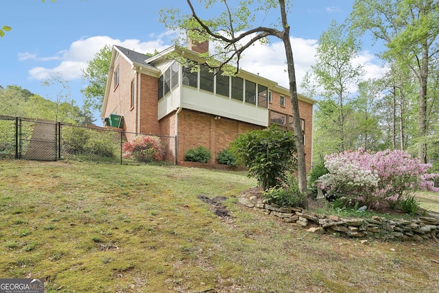 918 Guinevere Way SW, Lilburn, GA 30047 - view of property exterior featuring brick siding, a chimney, and a sunroom