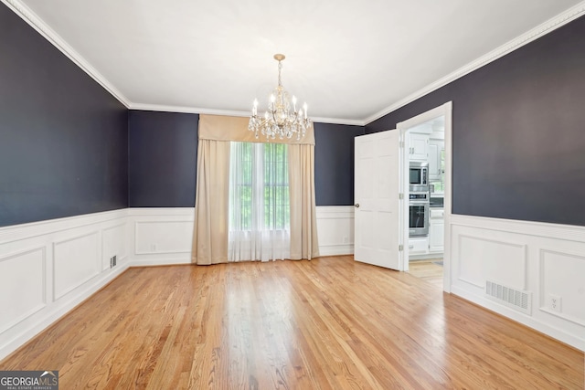 918 Guinevere Way SW, Lilburn, GA 30047 - spare room featuring a wainscoted wall, a chandelier, a decorative wall, light wood-style floors, and crown molding