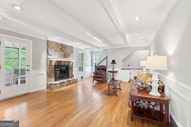 918 Guinevere Way SW, Lilburn, GA 30047 - living area with a decorative wall, a fireplace, a wainscoted wall, light wood finished floors, and crown molding