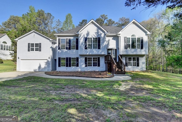 split foyer home with an attached garage, concrete driveway, and a front lawn