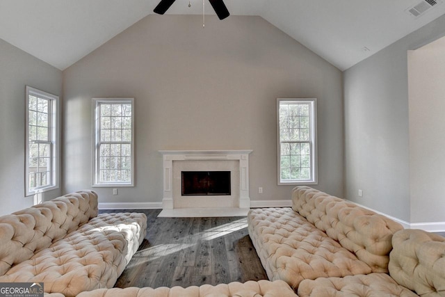 living area with wood finished floors, a ceiling fan, visible vents, and a wealth of natural light