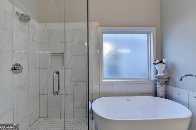 full bath featuring a shower stall and a soaking tub