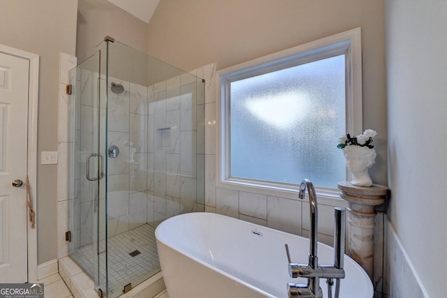 bathroom featuring a shower stall and a soaking tub
