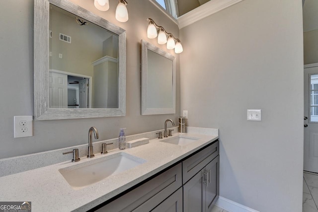 full bathroom with baseboards, double vanity, a sink, and visible vents