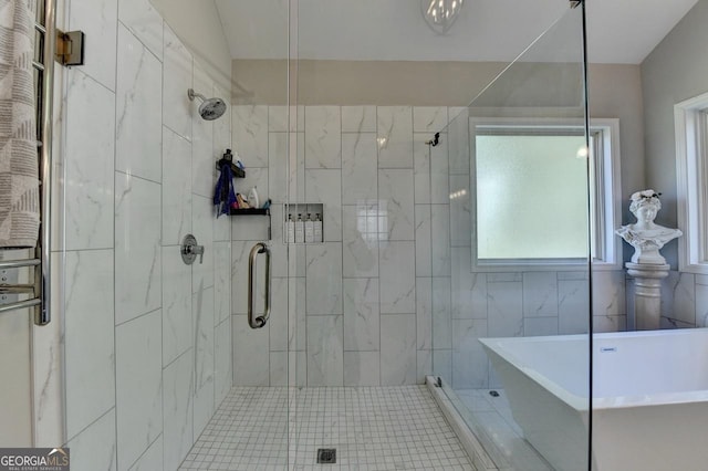 bathroom with a stall shower and a soaking tub