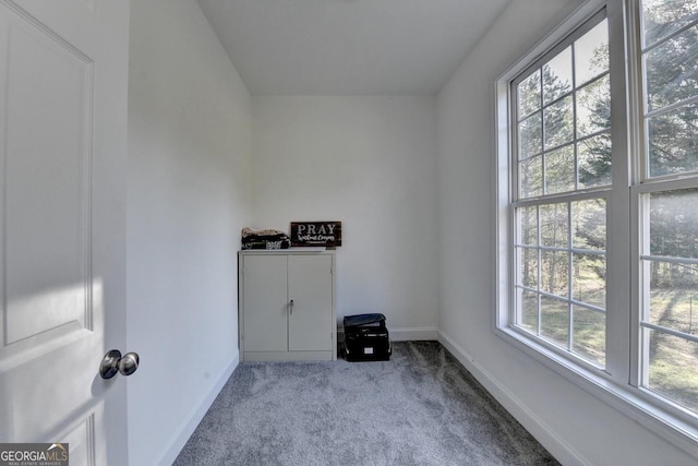 spare room featuring carpet and baseboards