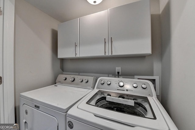 washroom with cabinet space and washing machine and dryer
