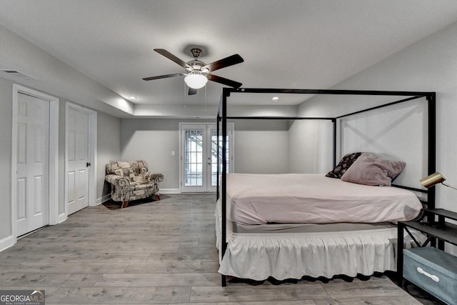bedroom with wood finished floors, baseboards, a ceiling fan, and visible vents