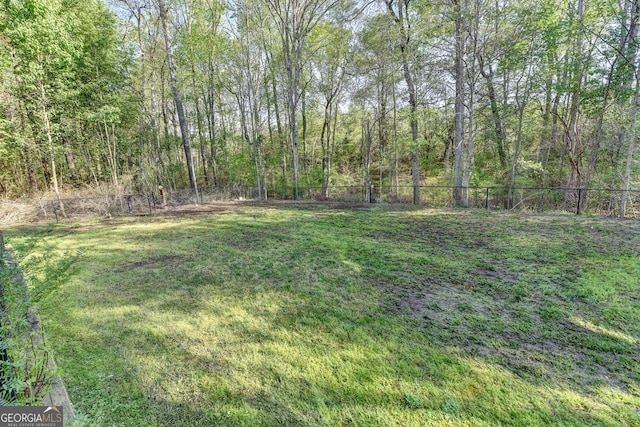 view of yard with a view of trees and fence