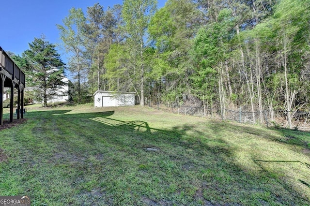 view of yard with fence and an outbuilding