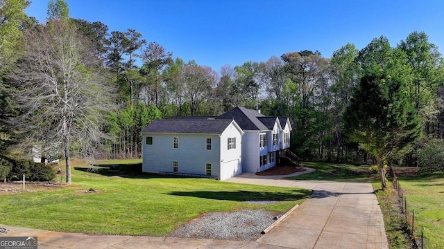 view of property exterior featuring a yard, driveway, and stairs