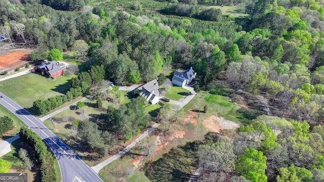 drone / aerial view with a wooded view